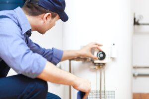 Technician Adjusting Hot Water Heater